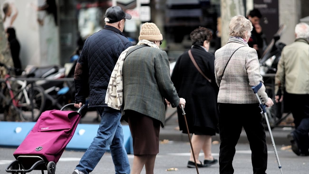 Varias personas mayores cruzan un paso para peatones en Madrid